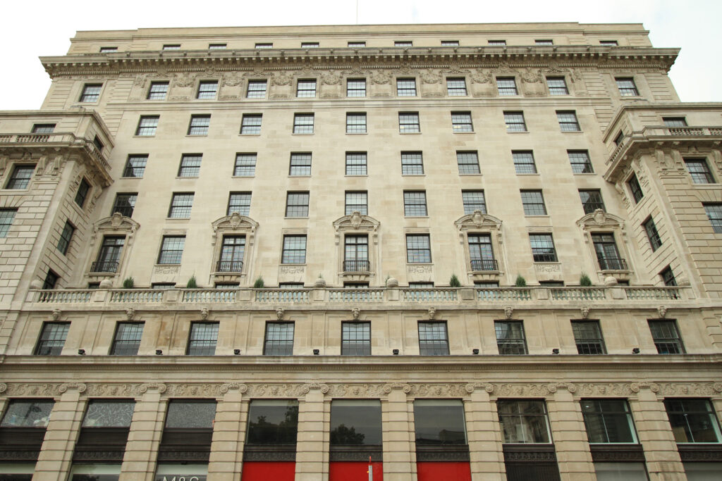 Styles Façade Solutions® delivers outstanding results with Façade Gommage, a scaffold-free cleaning process that restores heritage buildings like Devonshire House to the original pale Portland stone tone, revealing intricate carved detailing, cornicing and balustrades while preserving the fabric of this historic London landmark.