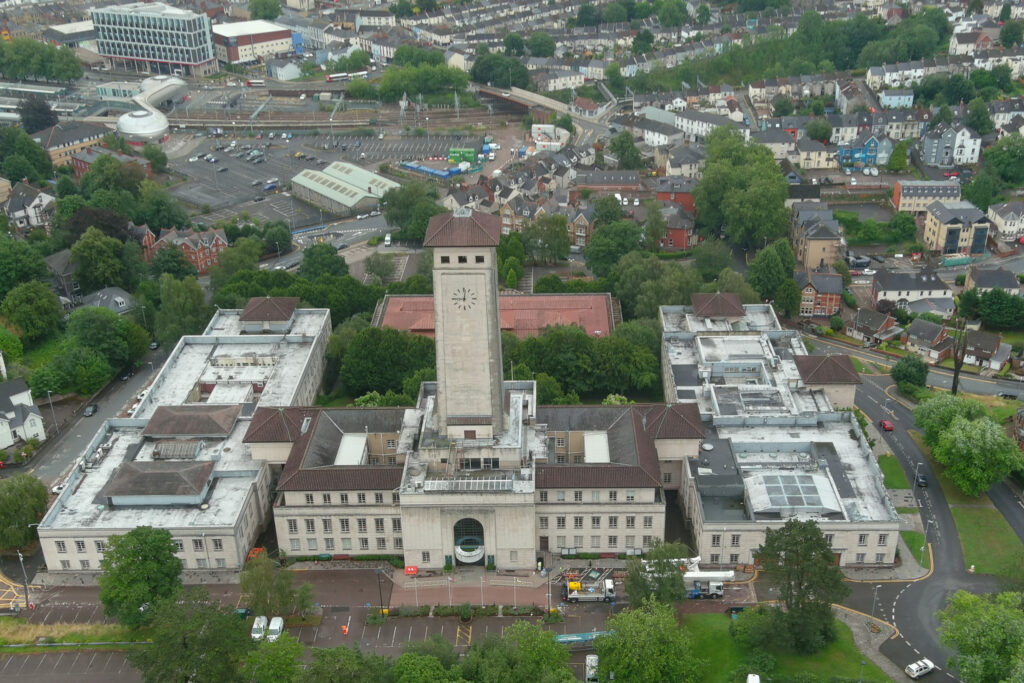 Styles Façade Solutions® sets up equipment at the base of Newport Civic Centre & Clock Tower, the Grade II* listed building in Newport, ready to begin the façade survey. MEWP vehicles are positioned at the entrance.