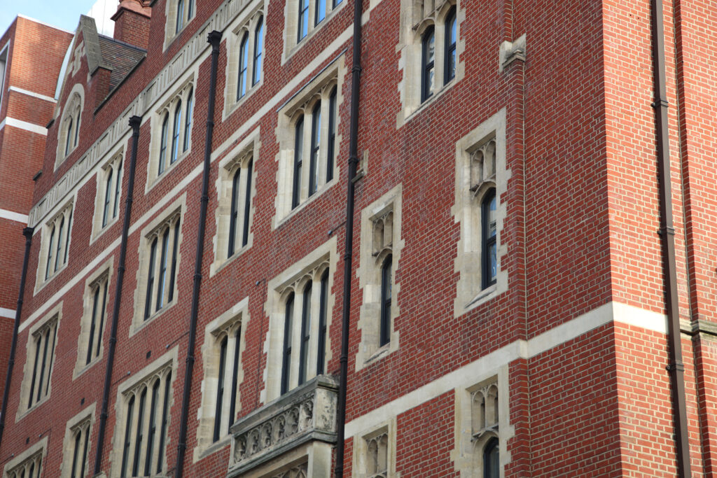 Styles Façade Solutions® brings expert care to heritage brickwork with its façade gommage cleaning process, gently lifting grime from intricate gothic stone dressings and red brick without abrasive damage. This precise, dust-controlled technique preserves historic character while revealing the true colour and craftsmanship beneath decades of pollution.