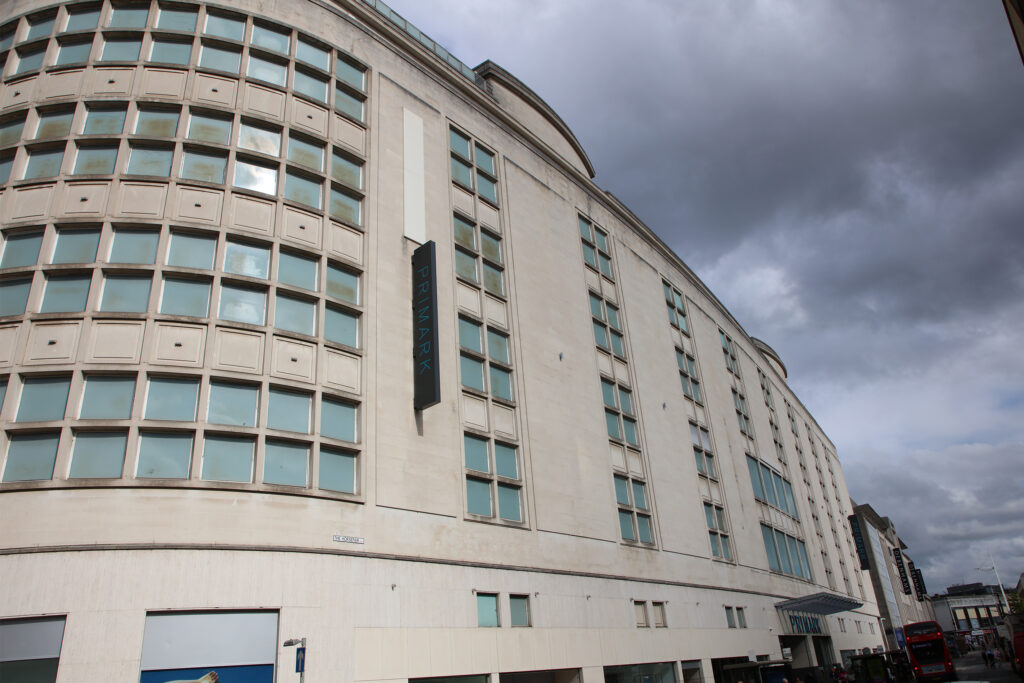 Styles Façade Solutions® prepares to clean and redecorate the Portland stone façade of 1-27 Horsefair, Bristol, home to Primark. The building's curved exterior shows significant weathering and staining across its windows and stonework, highlighting the restoration work required ahead of the project.