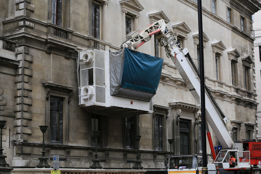 Styles Façade Solutions® cleaning the Portland stone façade of the Reform Club, London, using the Façade Gommage cleaning process. The image strikingly illustrates the contrast between the soiled and freshly cleaned stonework, demonstrating the transformative effect of the scaffold-free cleaning system on this Grade I listed Italianate building.
