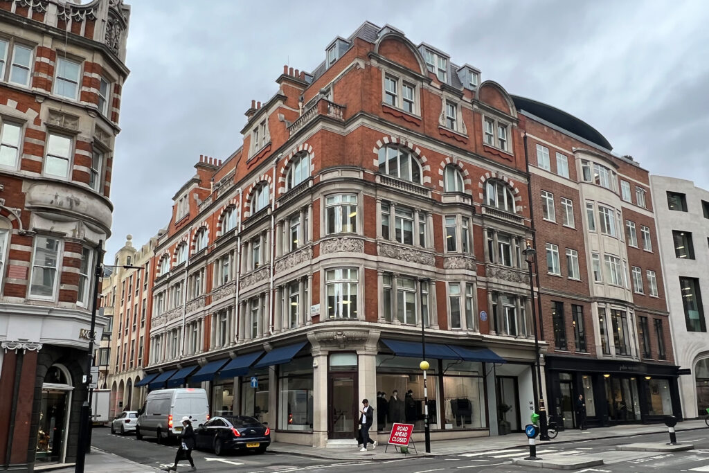 Styles Façade Solutions (formerly Thomann-Hanry®) was commissioned to clean the ornate red brick and Portland stone façade of 14–15 Conduit Street, London. The Edwardian corner building prior to cleaning with the Façade Gommage cleaning process, with atmospheric soiling and discolouration visible across the decorative stonework, frieze panels and arched window surrounds.