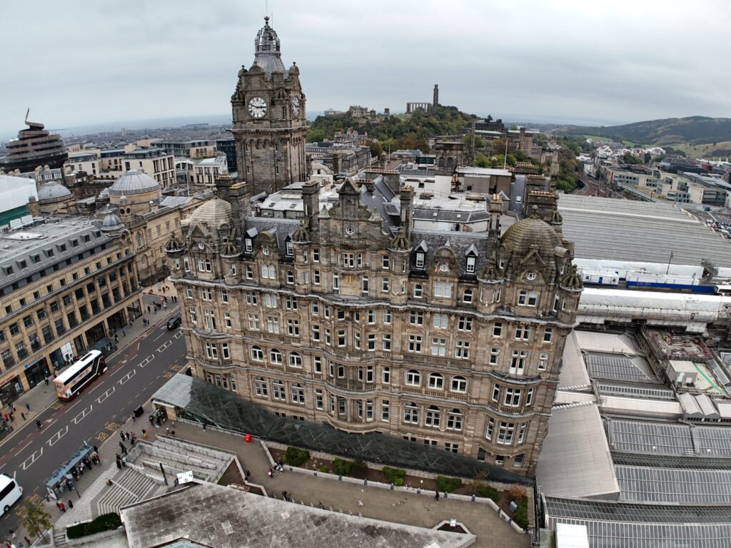 Drone survey image of the Balmoral Hotel Edinburgh conducted by Styles Façade Solutions (formerly Thomann-Hanry®), showing the full building elevation, roofscape and clock tower, captured as part of a commercial building survey and façade condition assessment.