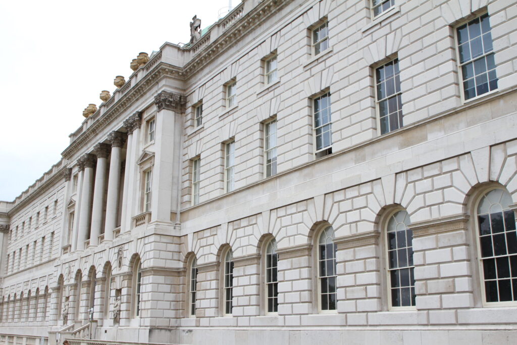 Somerset House's neoclassical Portland stone façade, with Corinthian columns, arched windows, and decorative roofline urns, appears bright and even-toned after cleaning. This refreshed finish reflects the results of the Façade Gommage cleaning process carried out by Styles Façade Solutions (formerly Thomann-Hanry®).