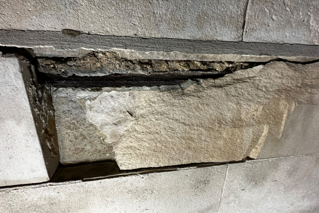 Styles Façade Solutions (formerly Thomann-Hanry®) documenting severe Portland stone spalling and delamination on the façade of Richmond Station, London, during a night-time façade condition survey. The survey recorded areas of significant structural deterioration, with some areas of the stone face detaching to expose degraded substrate and failed mortar, highlighting the urgent need for specialist stone repair intervention.