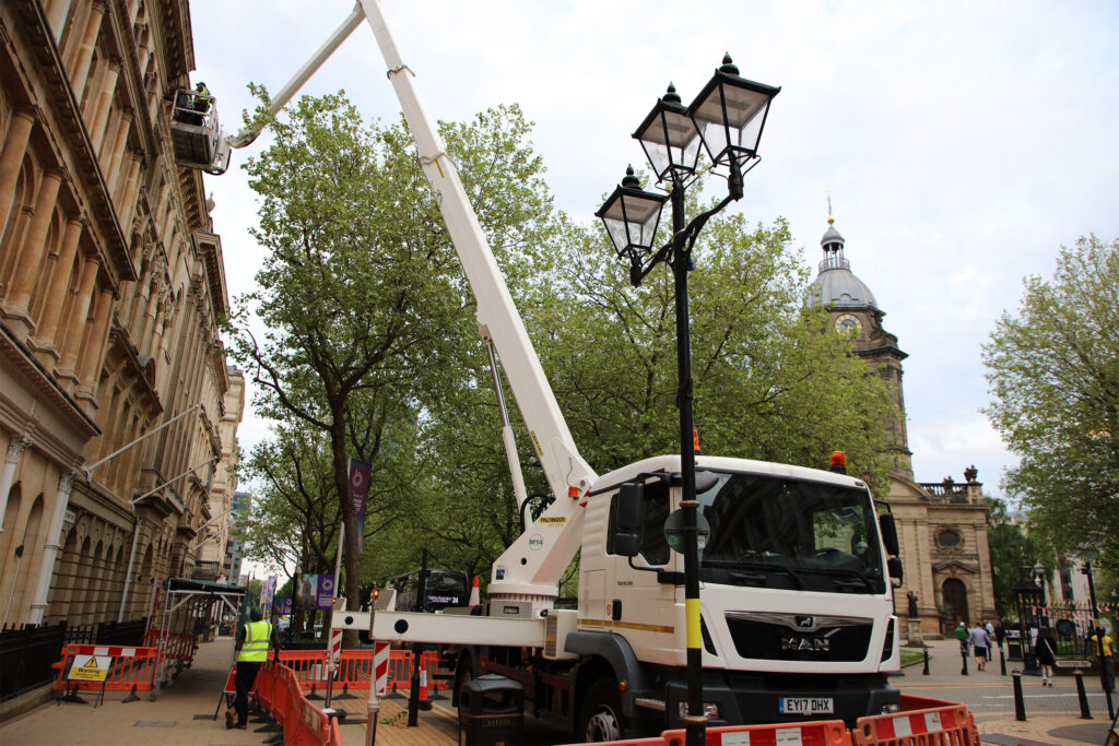 Styles Façade Solutions® deploys a truck-mounted platform with a fully certified, trained IPAF operator, extending high above a busy city street to reach upper-level façade work.