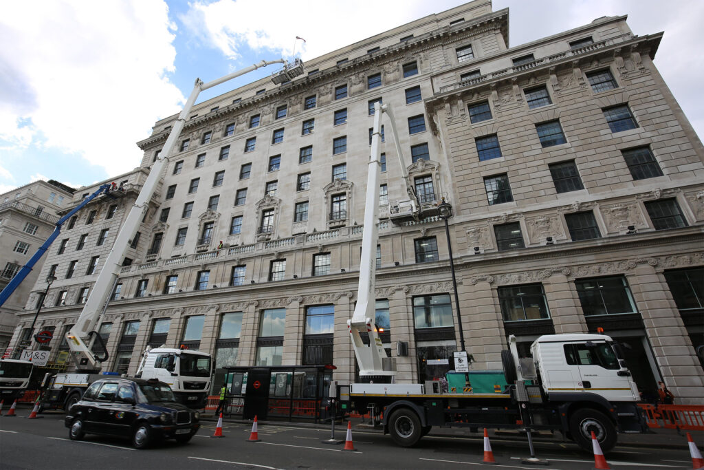 Styles Façade Solutions® carrying out scaffold-free restoration and stonemasonry on Devonshire House, London. Through the use of MEWPs to reach up the ornate classical façade, allowing Styles Façade Solutions team of skilled restorers to work at height on the façade without the need for full building scaffolding.