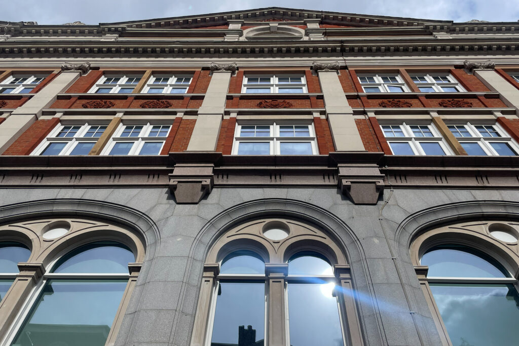 Styles Façade Solutions® highlights a striking mixed-material London façade combining granite, brick, sandstone and terracotta. The layered composition of arched windows, decorative panels and dentilled cornicing reflects classic Victorian craftsmanship.