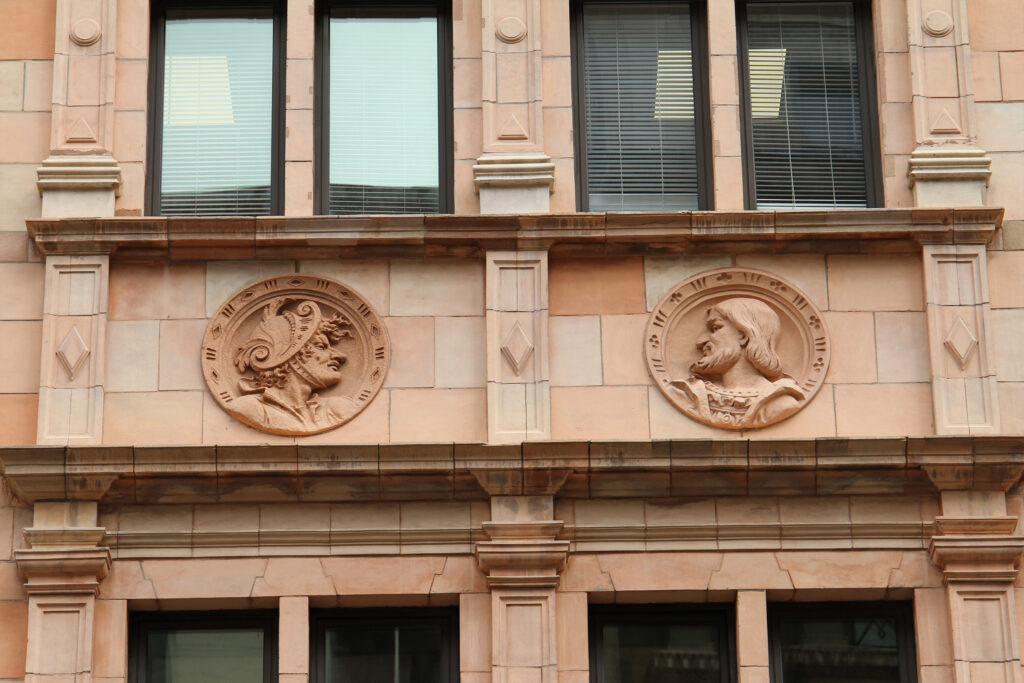 Styles Façade Solutions® showcases terracotta, a versatile and decorative façade material prized for sculptural detailing. This building's warm pink tones and intricately carved roundels demonstrate terracotta's durability and craftsmanship, ideal for heritage restoration and commercial properties seeking distinctive, ornamental architectural character.